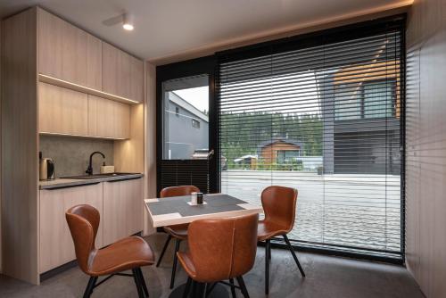 a kitchen with a table and chairs and a large window at A2 Apartment & Studio - Hrabovo, Ružomberok in Ružomberok
