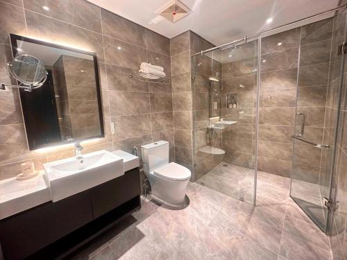 Hạ Long Sapphire Premium في ها لونغ: حمام مع مرحاض ومغسلة ودش