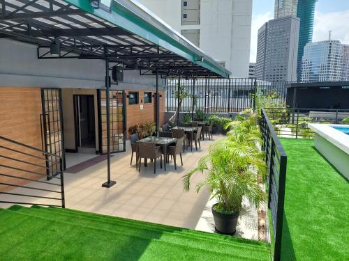 a patio with tables and chairs on the roof of a building at The Charter House in Manila