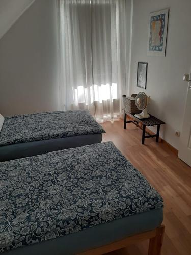 a bedroom with two beds and a table at Ferienwohnung an den Leinewiesen in Schwarmstedt