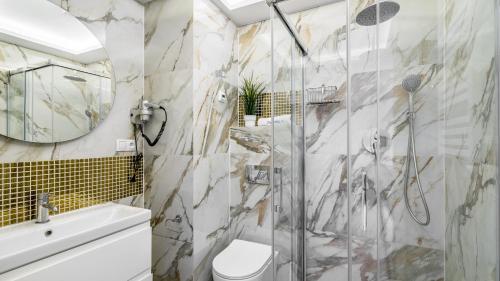 een badkamer met douche en toilet bij CONTINENTAL Apartamenty Piamola in Krynica Morska