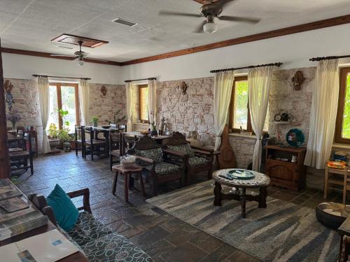 a living room with chairs and tables and windows at Pythaïs Hotel in Pythagoreio