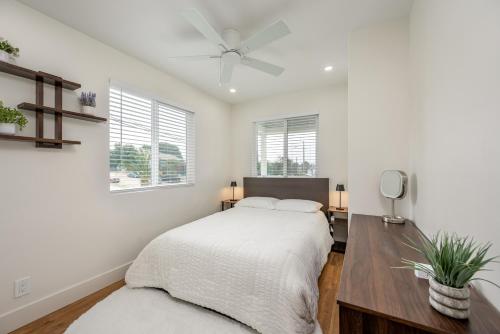 a white bedroom with a bed and a table at Modern home near Downtown San Diego in San Diego