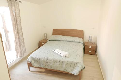 a small bedroom with a bed with a book on it at Appartamenti Renzo&Rita3 Teresina in SantʼAntìoco