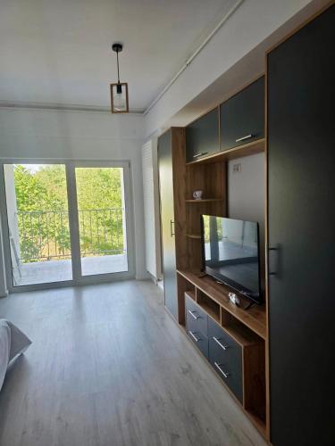 a living room with a television and a large window at Eva Studio in Văleni