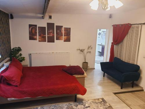 a bedroom with a red bed and a blue chair at Liliana Home in Bucharest
