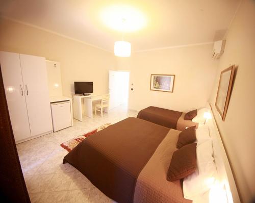 a bedroom with a bed and a desk and a television at Hotel Nika in Vlorë