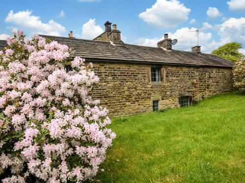 a brick house with pink flowers in front of it at 2 Bed in Longnor 78661 in Longnor