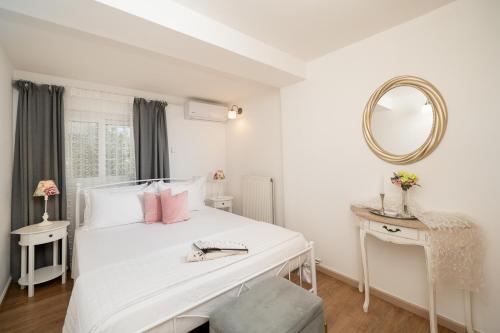 ein weißes Schlafzimmer mit einem weißen Bett und einem Spiegel in der Unterkunft Livingstone Cottage by A&D Properties in Porto Rafti
