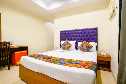 a bedroom with a large bed with a purple headboard at FabHotel Cruz Royale - Nr- Bandra West in Mumbai