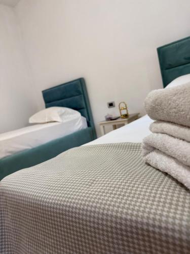 a bedroom with two beds with towels on the bed at Cozy Room Close to the Airport in Kamëz