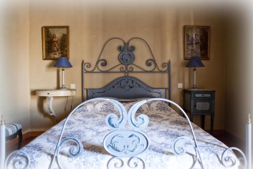 ein Bett in einem Schlafzimmer mit zwei Tischen und zwei Lampen in der Unterkunft gîte Mas Antinea in Mazan