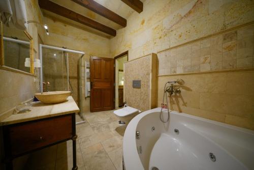 a bathroom with a tub and a toilet and a sink at Harman Cave Hotel in Goreme