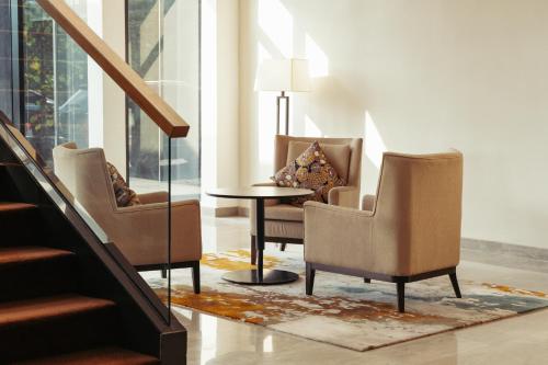 a living room with two chairs and a table at Impiana Hotel Senai in Kulai