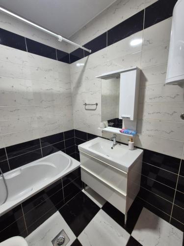 Un baño con bañera, lavabo y bañera. en Apartman Dvojka Banjaluka, en Banja Luka