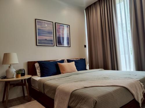 ein Schlafzimmer mit einem großen Bett mit blauen Kissen in der Unterkunft Chobjai Hostelry - Chaw Cher Home at Bang Kra Jao in Bang Krasop