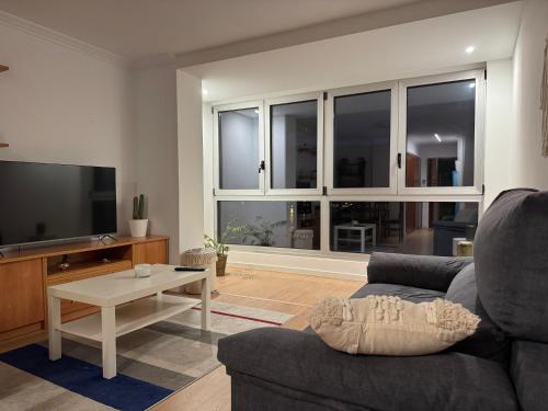 ein Wohnzimmer mit Sofa und Fernseher in der Unterkunft Playa Compostela in Vilagarcia de Arousa