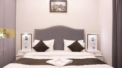 a bedroom with a large bed with white sheets and pillows at Sagar Villa Udaipur in Udaipur