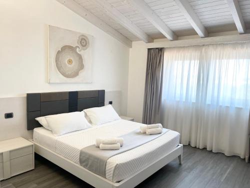 加拉托内Ferrocino Resort的卧室里有一张床，床上放着两条毛巾。