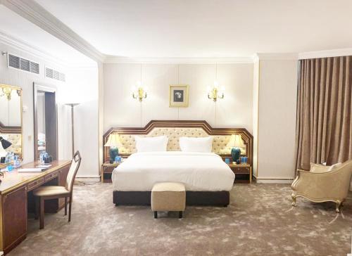 a bedroom with a large white bed and a desk at Al Shohada by Palm Rich Makkah in Makkah