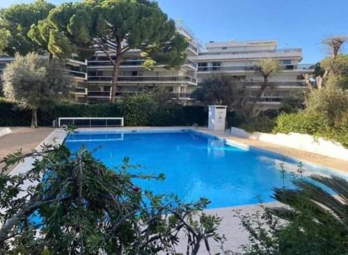 une grande piscine bleue devant un immeuble dans l'établissement Superbe appartement climatisé proche plages, grande terrasse et parking privé, à Antibes