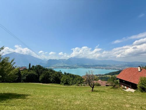 a house in a field with a view of a lake at Apartment Panorama in Heiligenschwendi