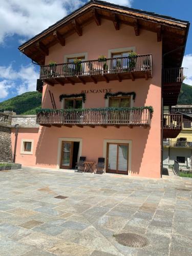 a pink house with a balcony and a patio at Centralissima e comoda agli impianti di risalita - La Casa Rosa - Limone Piemonte in Limone Piemonte