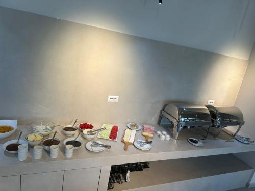 eine Küchentheke mit Schalen und Teller mit Lebensmitteln in der Unterkunft Mahoro Boutique Hotel in Vlorë