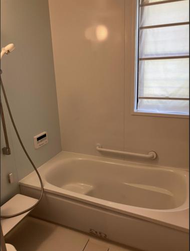 a white bath tub in a bathroom with a window at 茶々ハウス in Fujiyoshida
