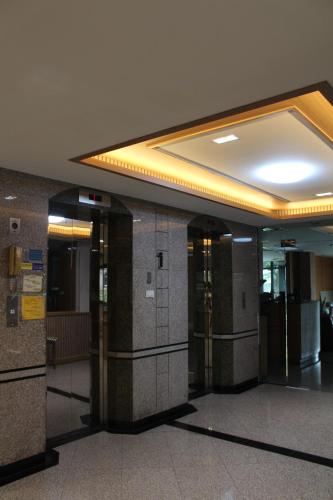 a lobby with a row of elevators in a building at Bangkok Place Apartment - EKAMAI BTS in Bangkok