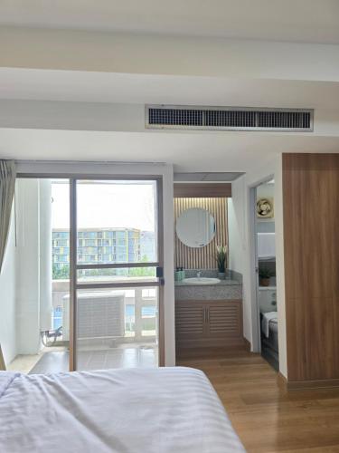 a bedroom with a bed and a bathroom with a mirror at Bangkok Place Apartment - EKAMAI BTS in Bangkok