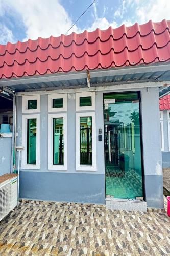 a house with a red roof and windows at Darul Salam Inn in Kertih