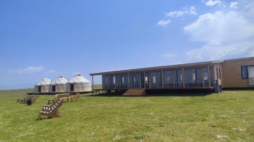 a building with two domes on top of a field at Yurt Camp Ali-Nur, Lake Song-Kul , Kyrgyzstan, Юрточный лагерь Али Нур, на берегу озера Сон Кол in Naryn