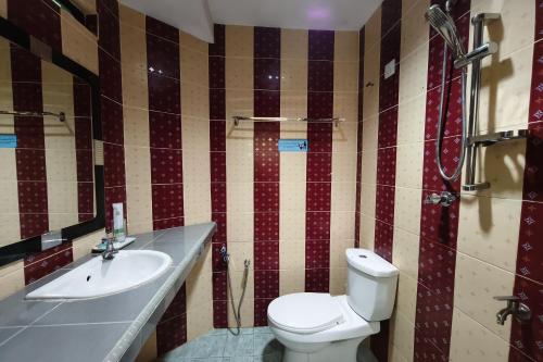 a bathroom with a toilet and a sink at Darul Salam Inn in Kertih