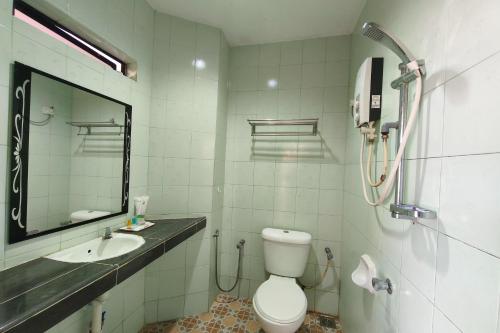 a bathroom with a toilet and a sink and a mirror at Darul Salam Inn in Kertih