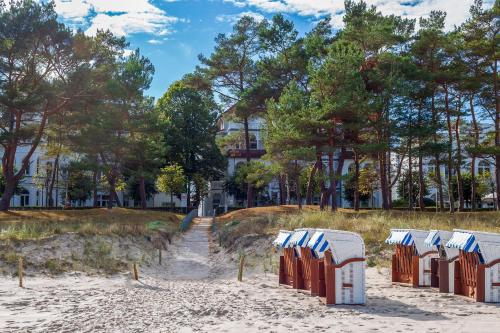 une rangée de chaises longues sur une plage de sable dans l'établissement Villa Strandidyll Apartment 15, Meerblick, inkl Strandkorb, à Binz