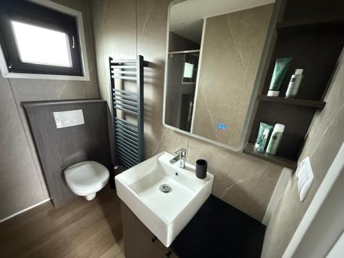a bathroom with a white sink and a toilet at Nieuw in 2025! Modern vakantiehuis aan de Waddenzee in Westerland