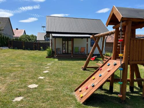 a playground with a wooden slide in a yard at Domek u Gołąbków Bieszczady in Lesko
