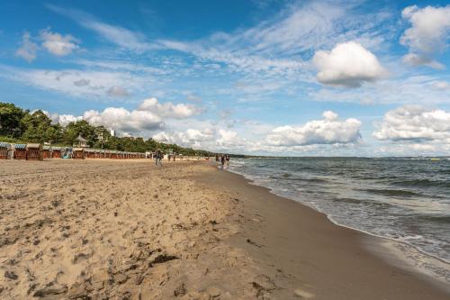 a group of people walking on the beach at Villa Strandidyll Neubau Ferienwohnung 1 2 mit Balkon in Binz