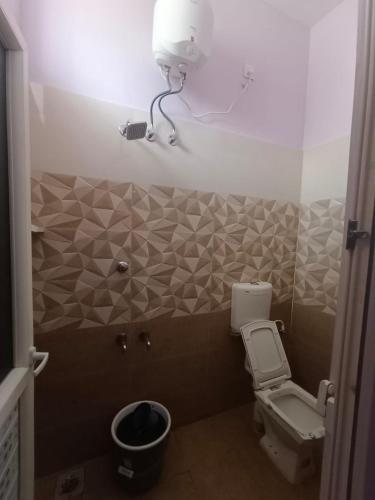 a bathroom with a toilet and a camera on the wall at Christmas Rajan Home Stay in Tirunelveli