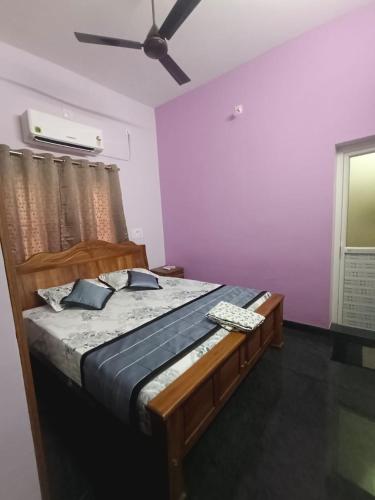 a bedroom with a bed with a ceiling fan at Christmas Rajan Home Stay in Tirunelveli