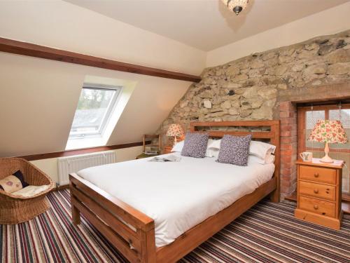 Un dormitorio con una cama y una pared de piedra. en 2 Bed in Godshill IC072, en Godshill