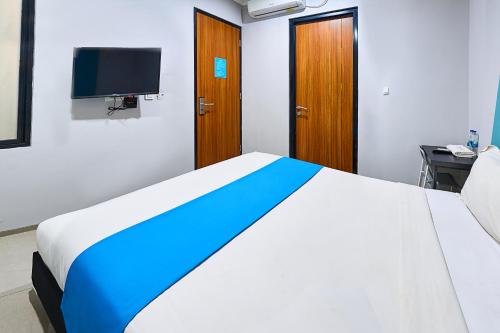 a bedroom with a large bed with a tv on the wall at Bale Resident in Jakarta
