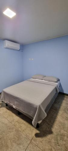 マナグアにあるApartamento Las Brisas Managuaの青い壁の部屋にあるベッド