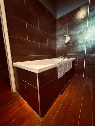 a bathroom with a white sink and a wooden floor at chateau Laprade Narbonne in Narbonne