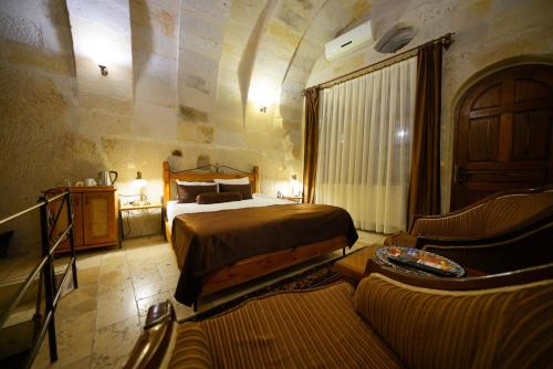 a bedroom with a bed and a couch in a room at Harman Cave Hotel in Goreme