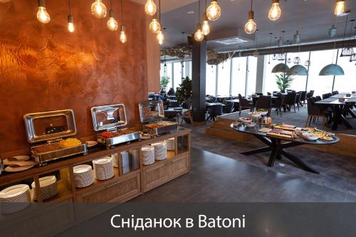 a dining room with tables and chairs and a buffet at Fomich Residence in Bukovel