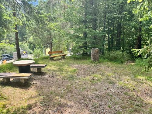two benches and a picnic table in a park at Martinov dom in Kranjska Gora