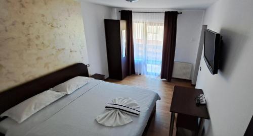 a bedroom with a bed with a hat on it at Casa Raul Borșa in Borsa