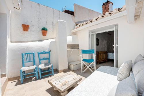 a room with two chairs and a bed and a table at Casa Bonita Residencia in Alcaucín